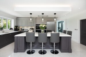 an elegant in frame hand painted kitchen with traditional mouldings and a large island