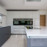 Striking Niel white shimmer quartz worktop with matching full clad on the wall. With undermounted Blanco stianless steel sink and matching Culina spray tap acompanied by a Quooker hot tap.