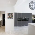 Matt graphite handless tall unit run housing Siemens intergrated applinaces consisting of 2 full size single ovens, a combinantion microwave oven and warmming drawer for all your cooking needs.