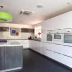 Two tone pearl grey and polar white gloss kitchen units with high end Miele integrated appliances in white.