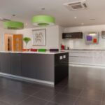 Monotone modern kitchen accessories with pops of bright colour. With LED plinth lights and under cupboard wall lights.