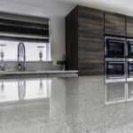 Light bright and earthy warm tones throughout this Hacker handless kitchen help create a welcoming atmosphere with the cool modern look of the appliances and fixtures.